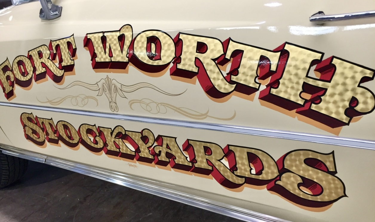 Sign with text 'Fort Worth Stock Yards' in decorative lettering on a vehicle door.