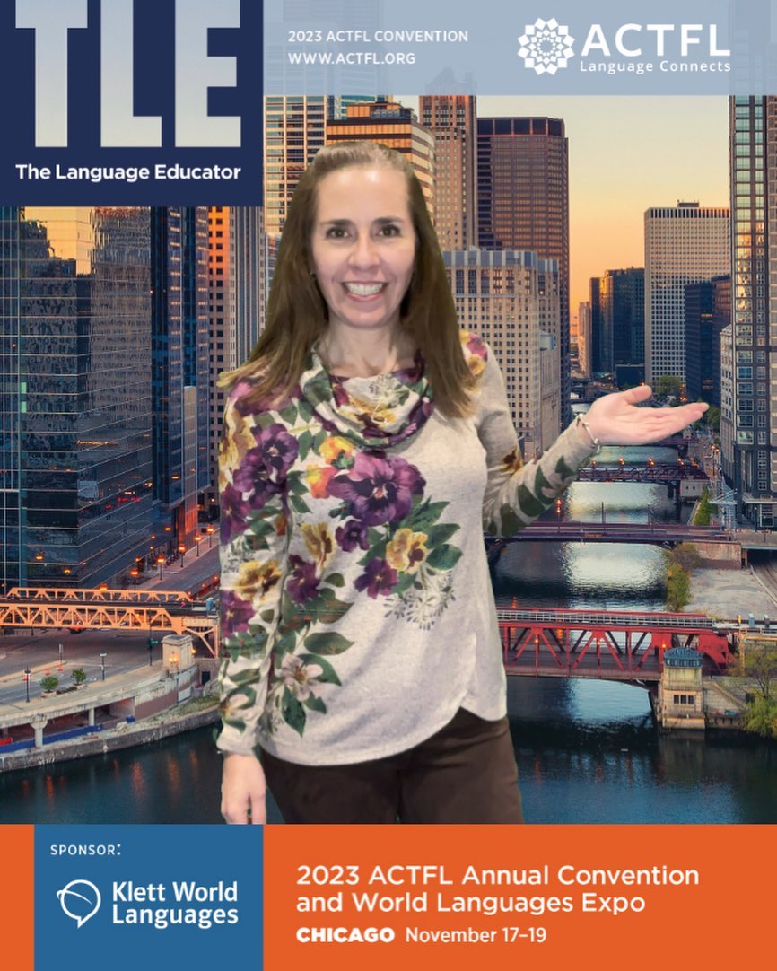 Woman smiling with city skyline and river in background, wearing a floral sweater, gesturing with her right hand.
