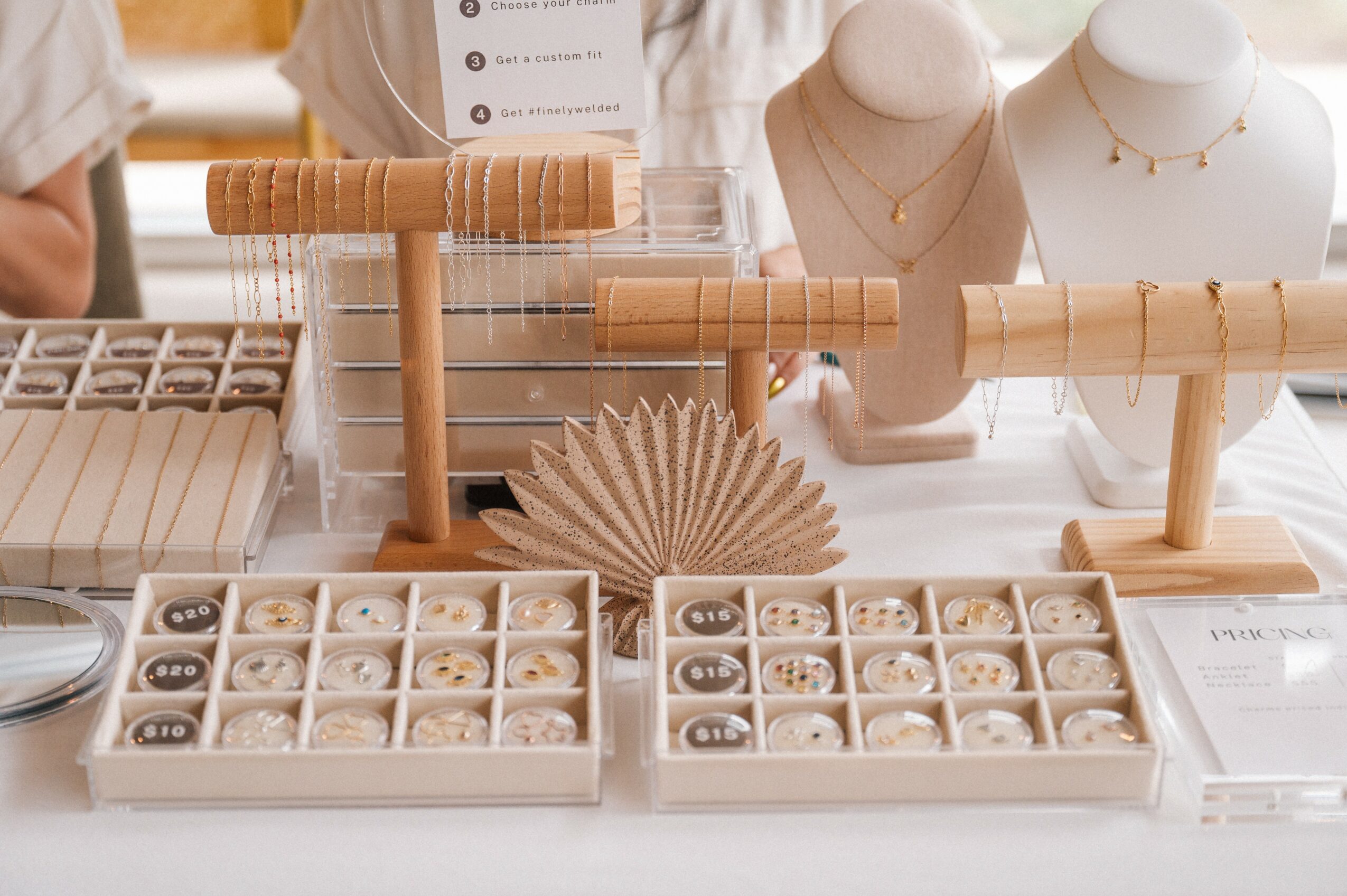 Jewelry display with necklaces, rings, and jewelry stands on a table, with organized jewelry boxes in front.