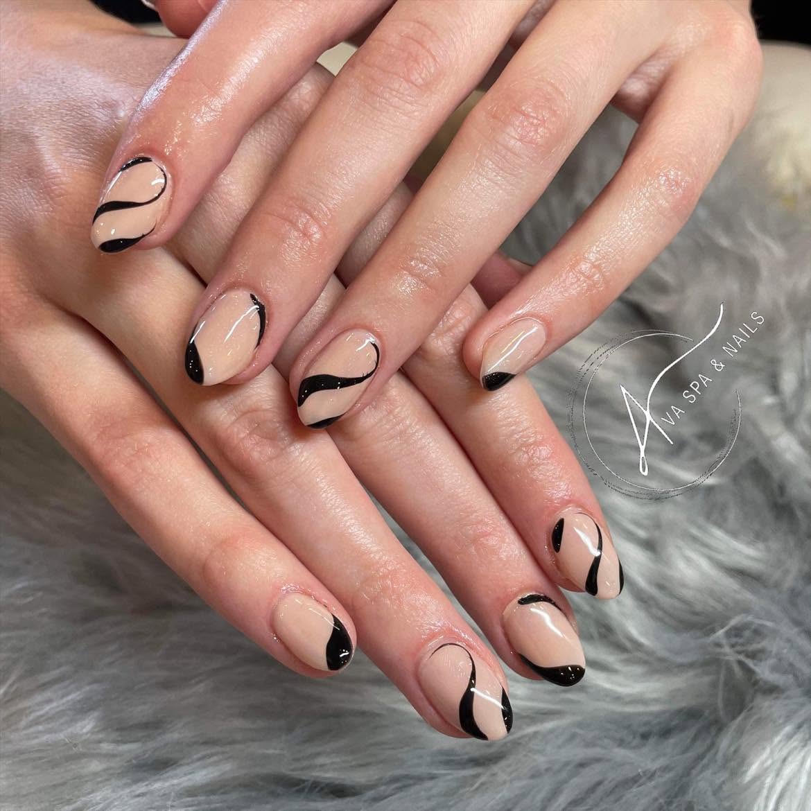 Close-up of hands with manicured nails featuring black and nude geometric designs, resting on a soft, furry surface.