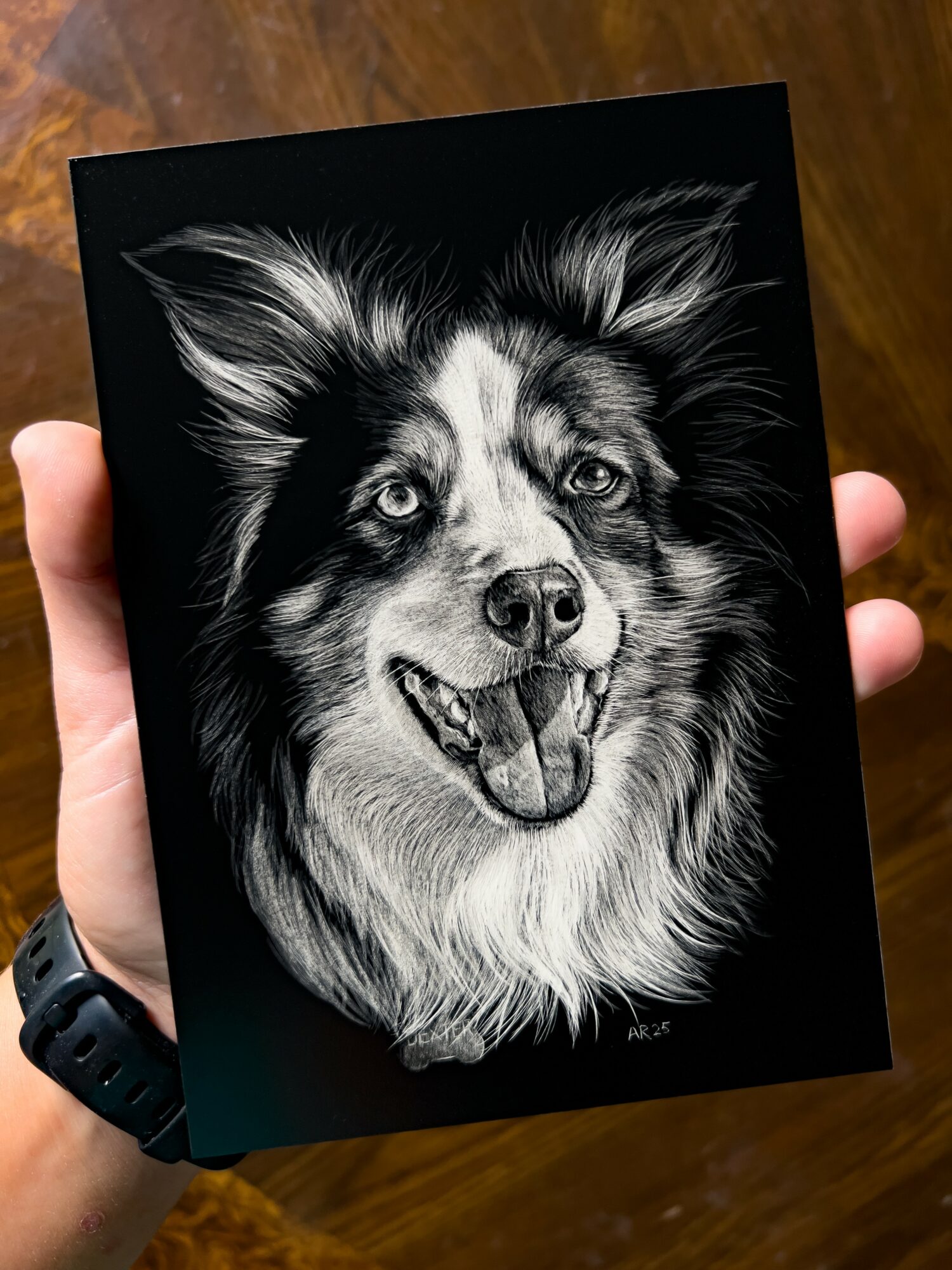 Black and white detailed drawing of a happy dog with open mouth and bright eyes, on a black background.