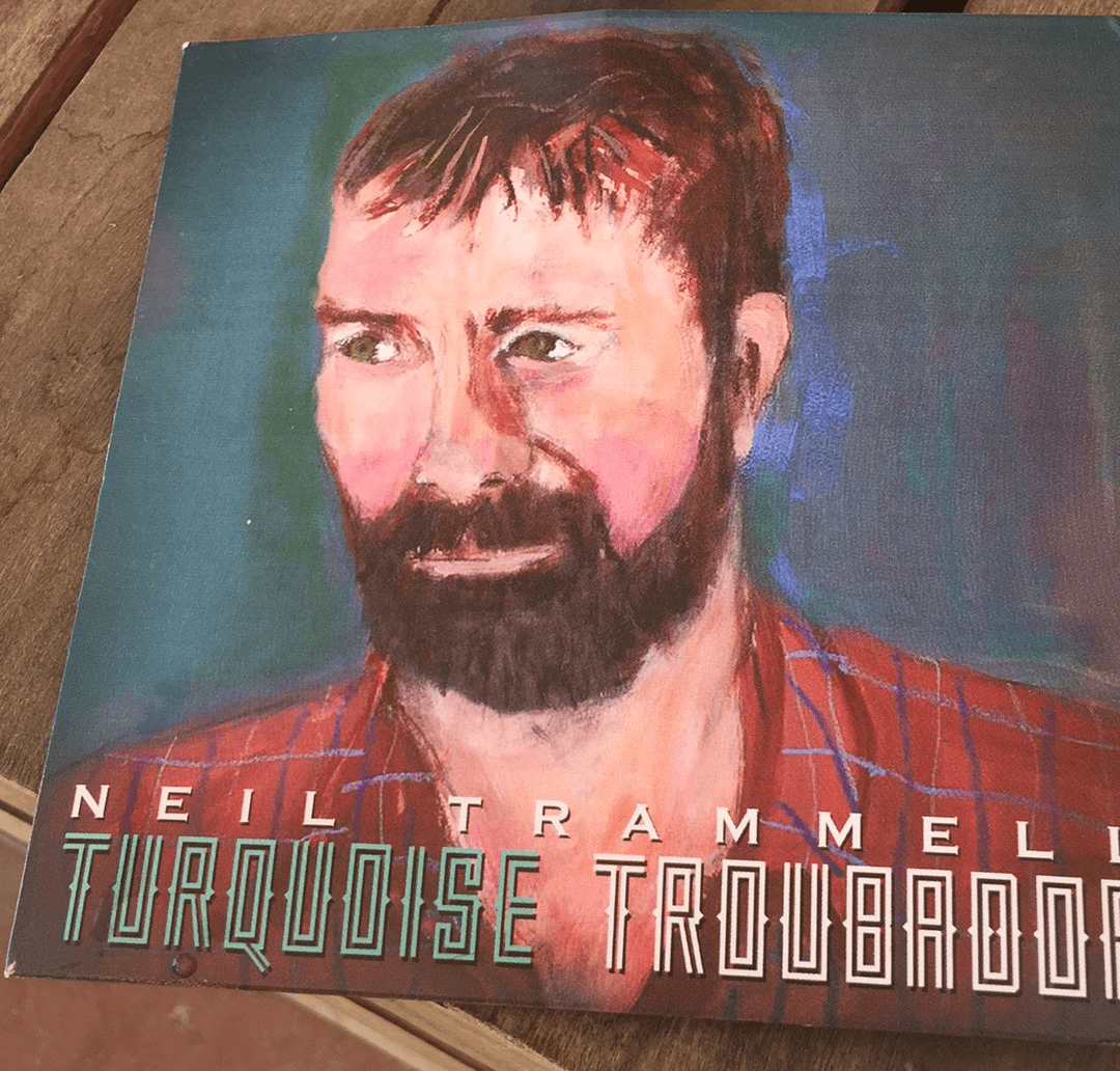 Painting of a man with a beard and short hair, wearing a red plaid shirt, against a blue background.