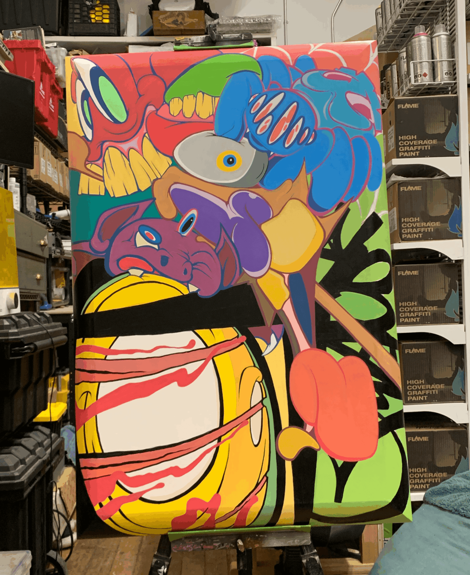 Colorful abstract painting with various shapes and patterns, including a purple creature, a yellow object, and a pink flower, on a canvas.