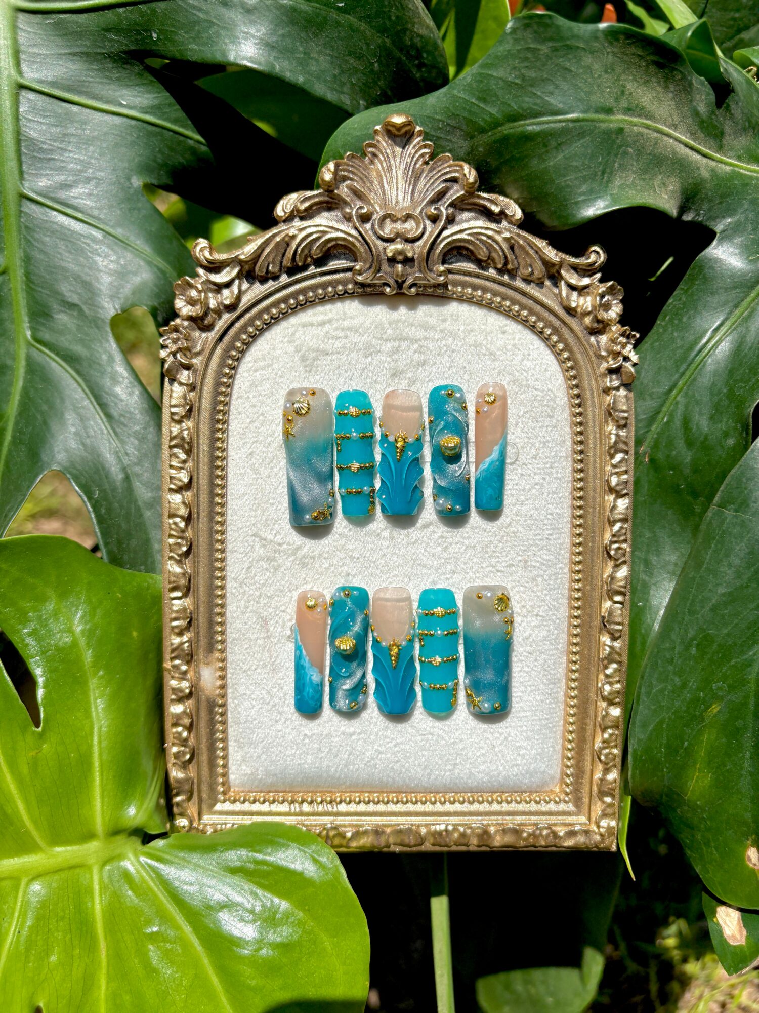 Decorative frame with the words 'MI MI' in blue and gold, surrounded by green leaves.