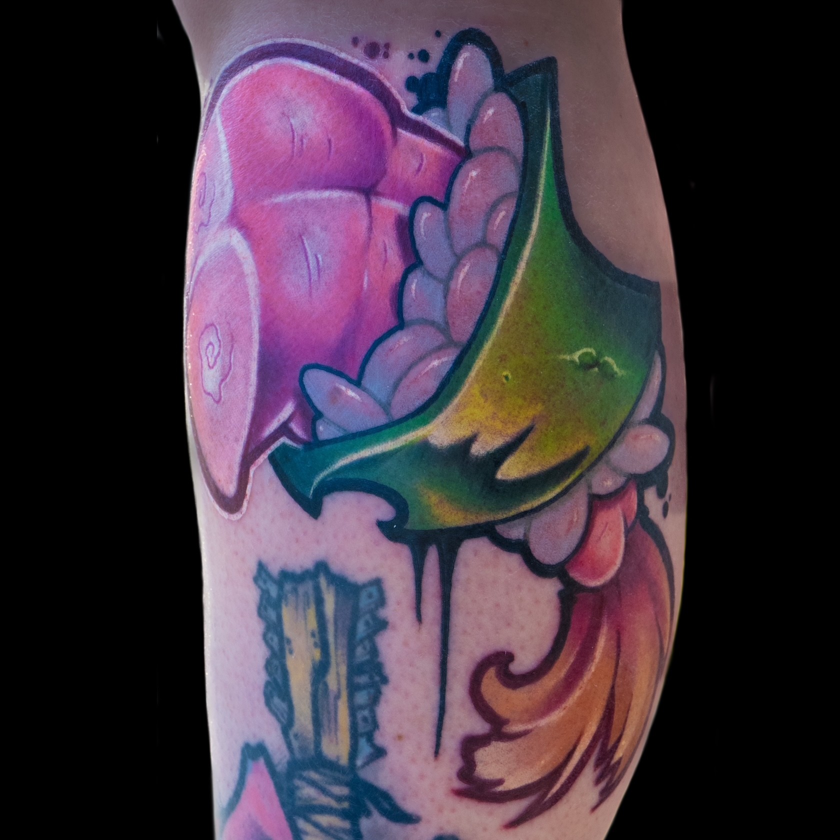 Colorful tattoo of a pink and purple whale, green and yellow fish, and orange hair on a person's side.