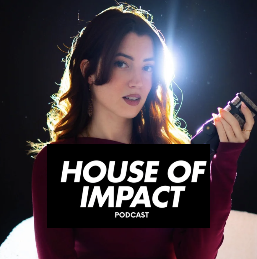 Young woman with dark hair holding a phone, backlit with bright light, wearing a dark top, in a dark background.