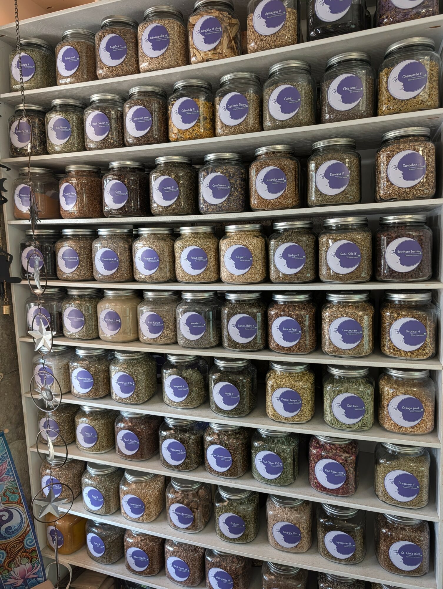 Shelves filled with jars of peanut butter, each jar has a purple and white label, arranged in rows.