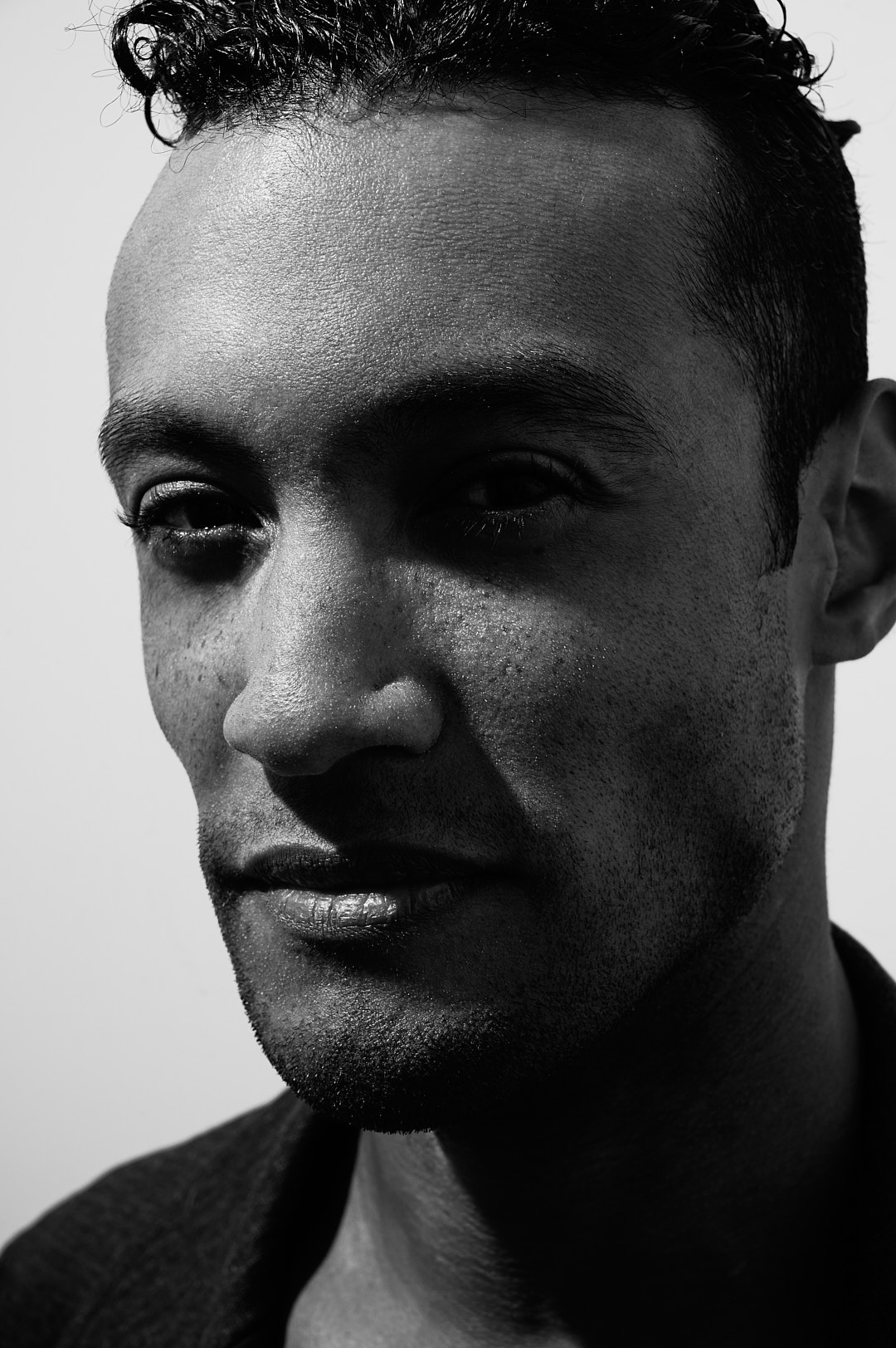 Close-up of a person's face in black and white, with high contrast and detailed facial features.