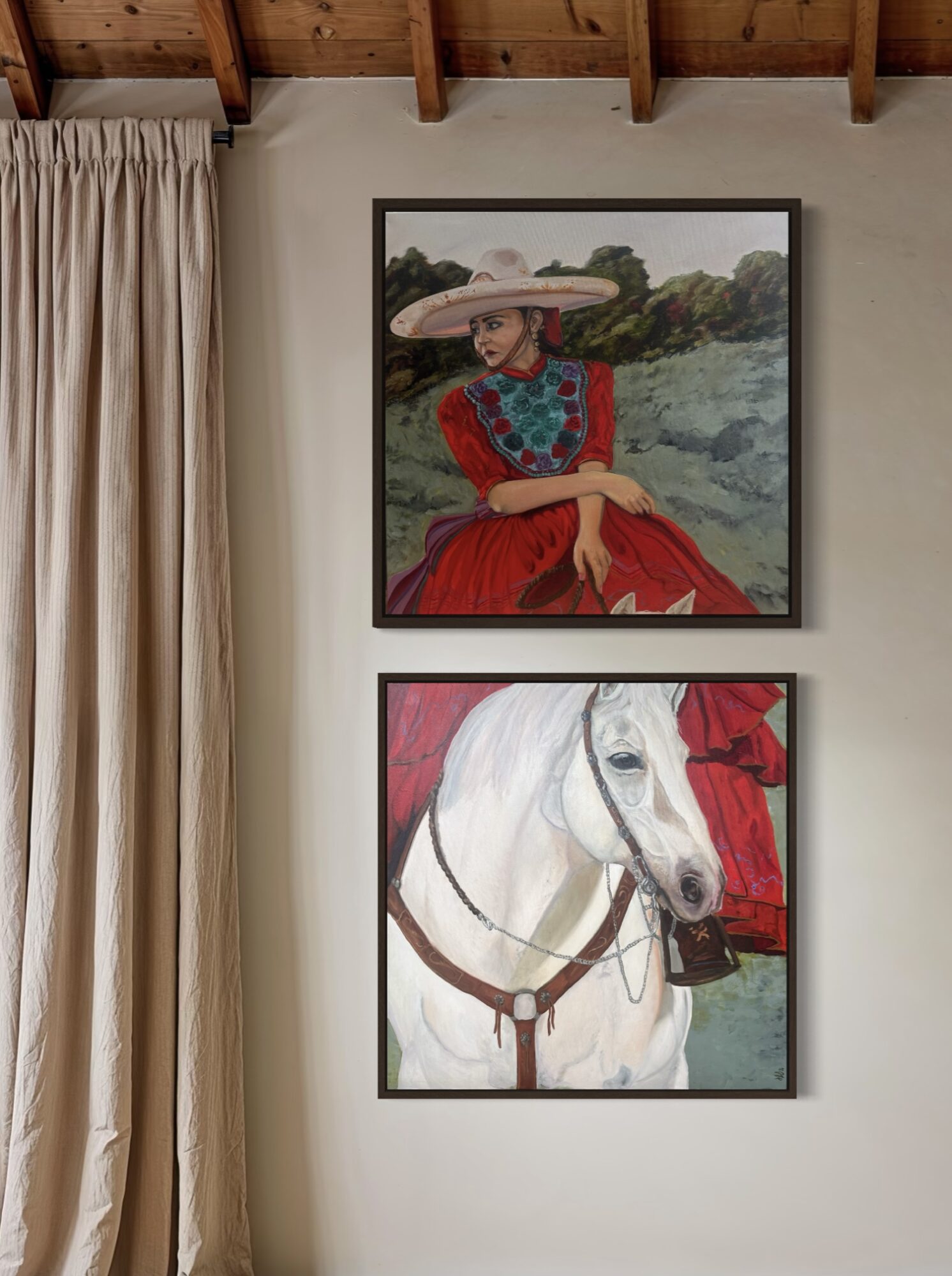 Two framed paintings on a wall, one of a woman in a hat and red dress, the other of a white horse with a red background.