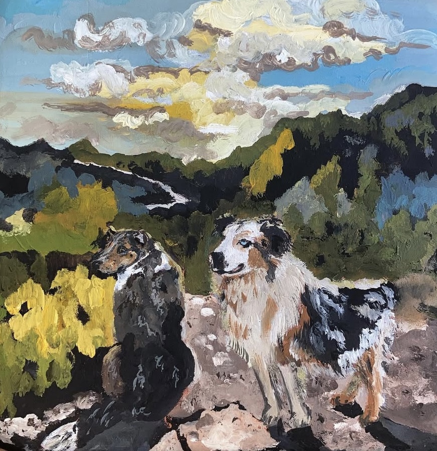 Two dogs sitting outdoors with a landscape of trees and a cloudy sky in the background.