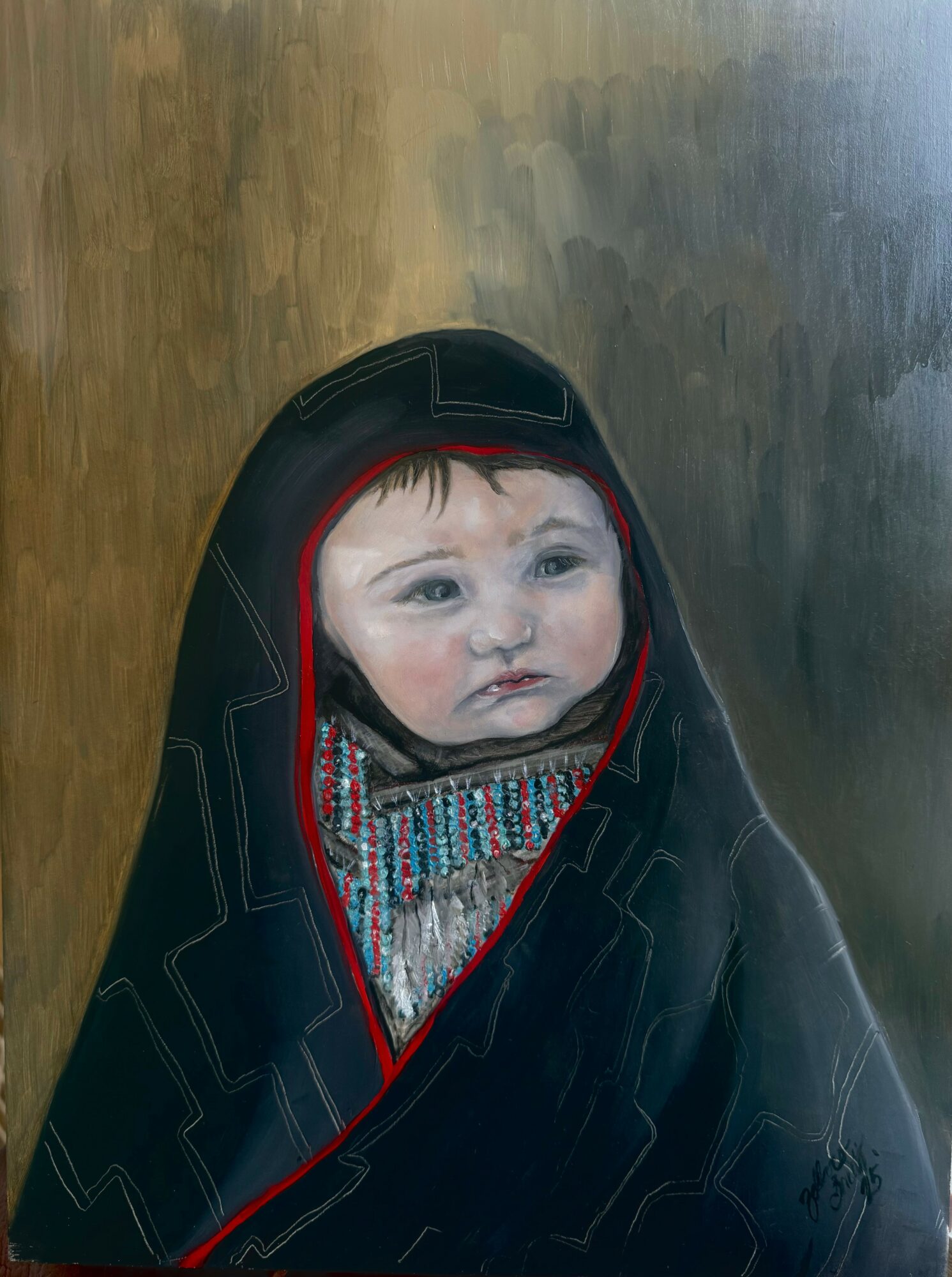 Child wrapped in a dark hooded garment, with a patterned scarf visible, against a plain background.