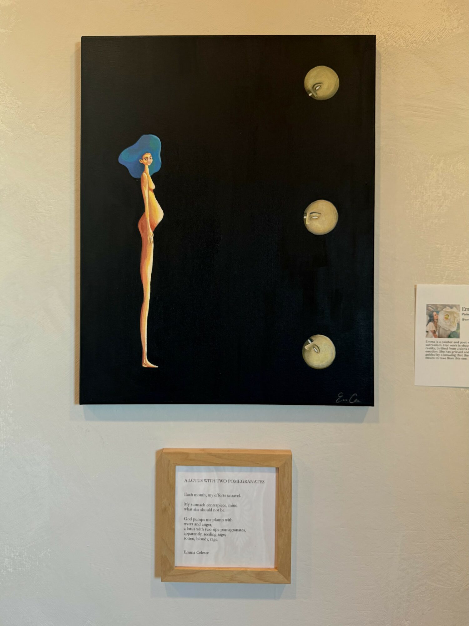 Vertical painting of a woman with blue hair on a black background, three circular objects to the right, framed text below.