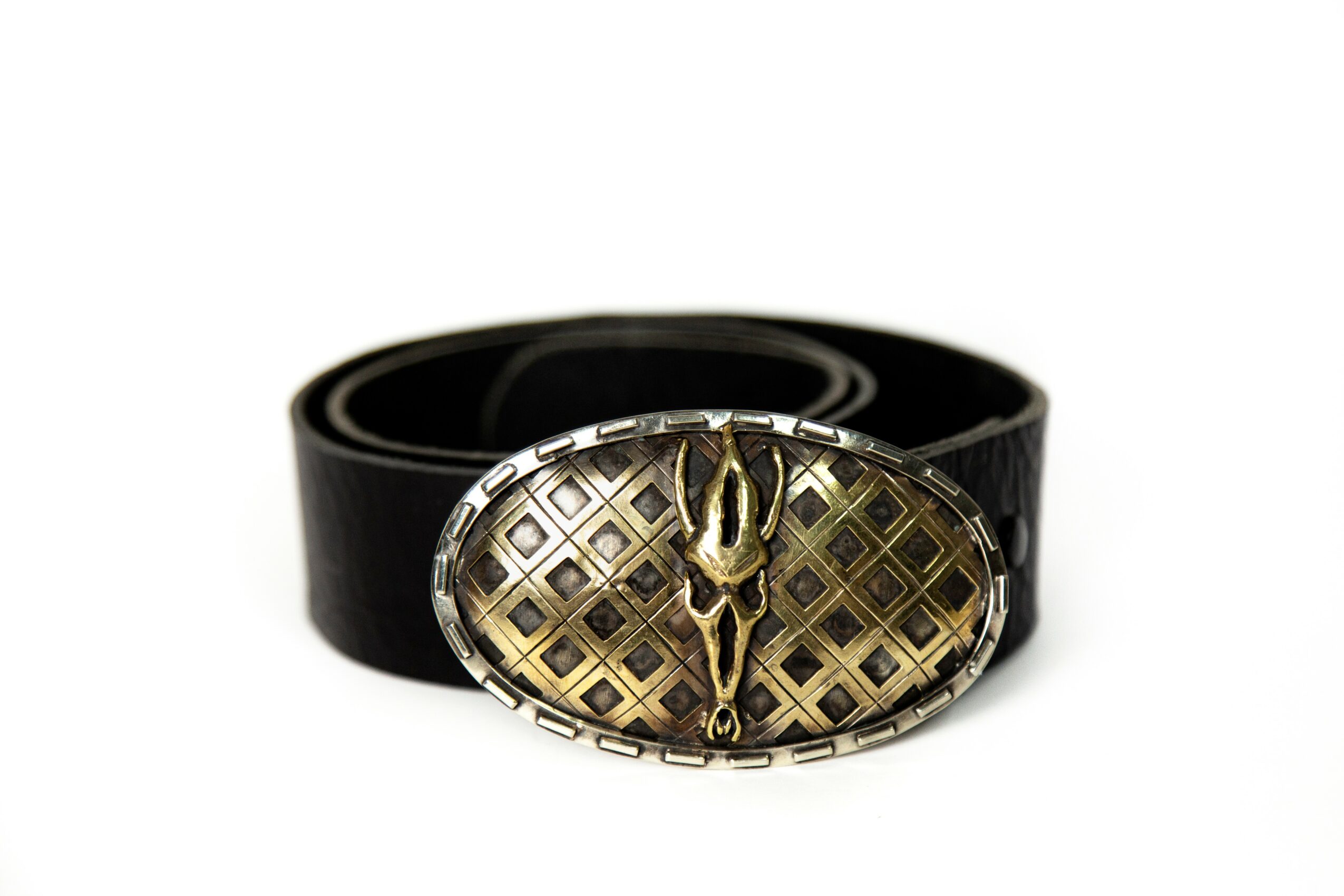 Black belt with an oval silver buckle featuring a gold emblem and a lattice pattern, coiled on a white background.