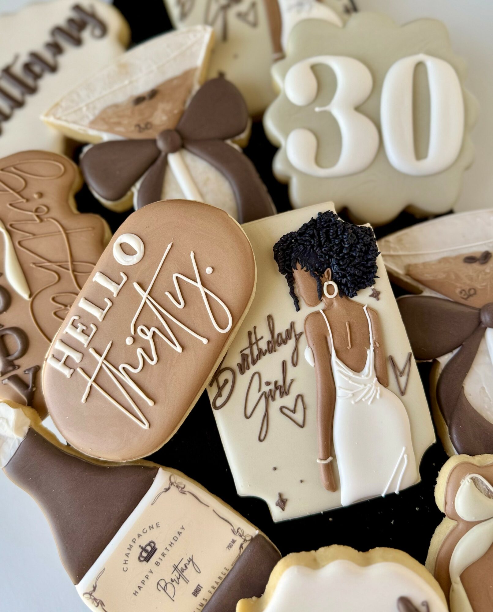 Decorative cookies and cake topper celebrating a 30th birthday, featuring a woman in a white dress and a large number 30.
