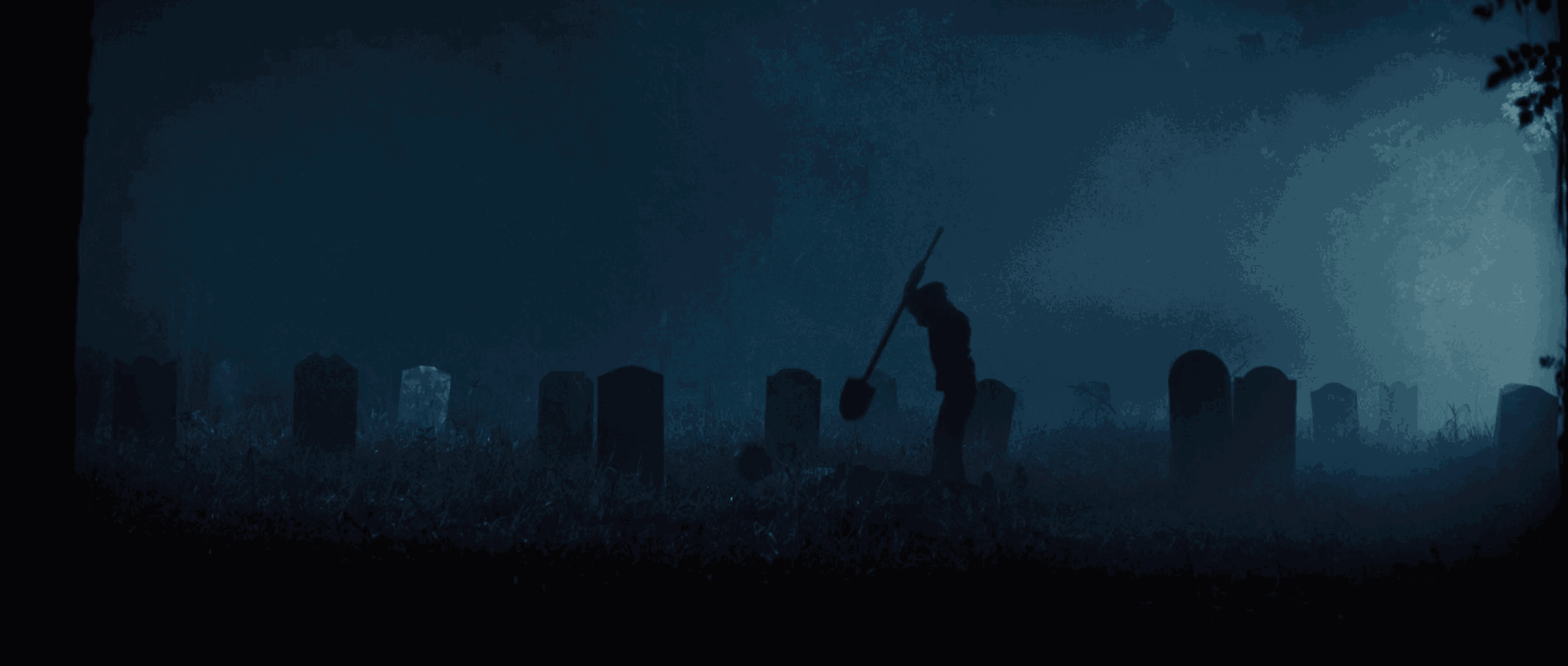 A person holding a weapon in a foggy graveyard at night, surrounded by tombstones and trees.