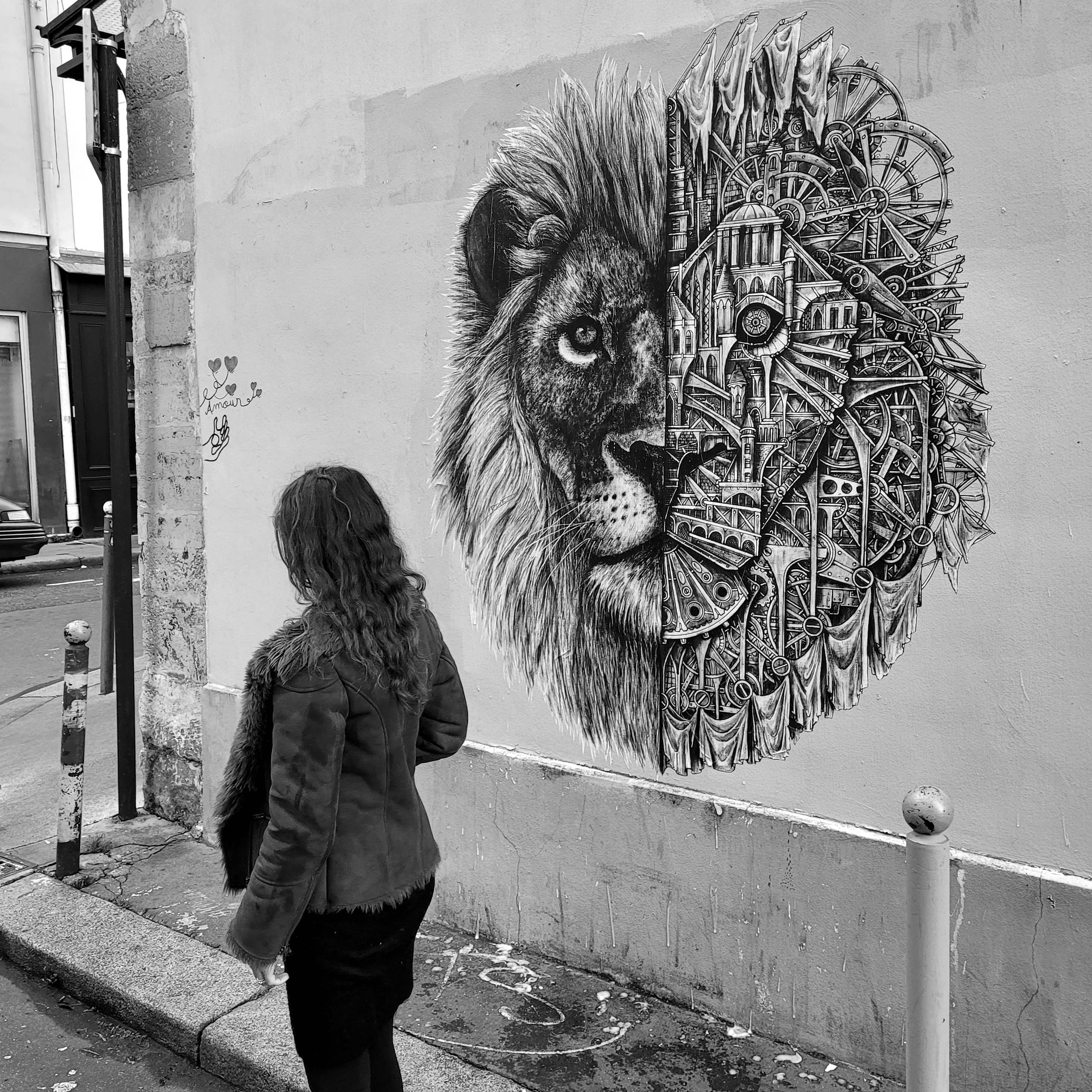 Person with long hair and jacket looking at a lion mural on a wall, with a detailed artistic style.
