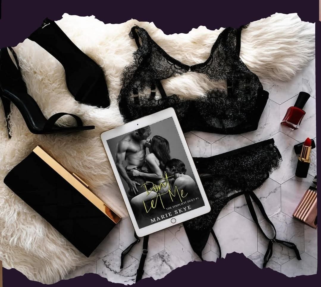 Black lace lingerie, a book, makeup items, and clothing accessories arranged on a surface.