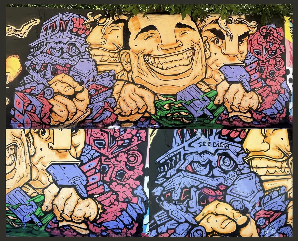 Colorful graffiti mural with smiling cartoon characters holding objects, surrounded by abstract patterns and vibrant colors.