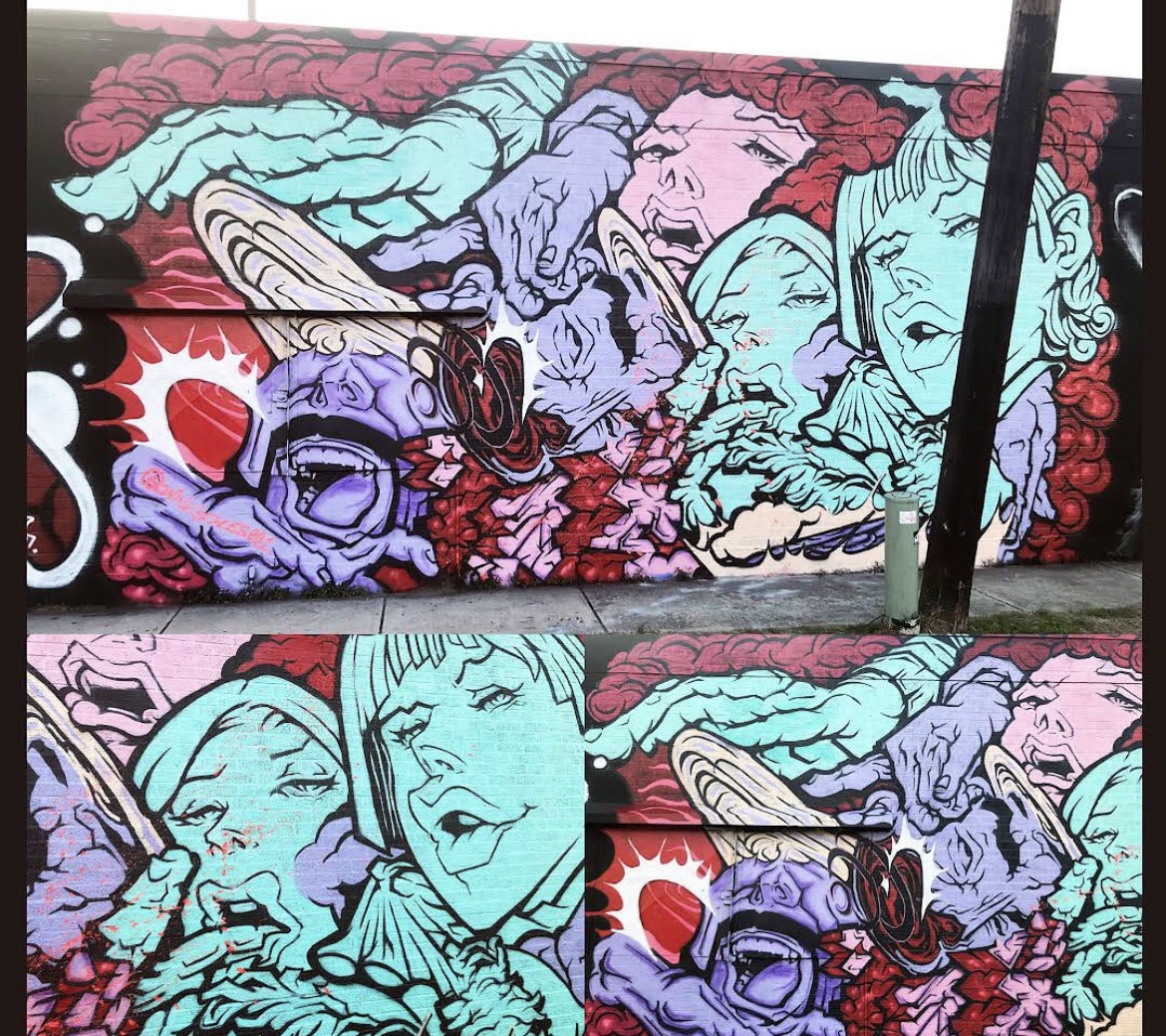 Colorful graffiti mural featuring stylized faces and abstract shapes in pink, blue, purple, and red hues.