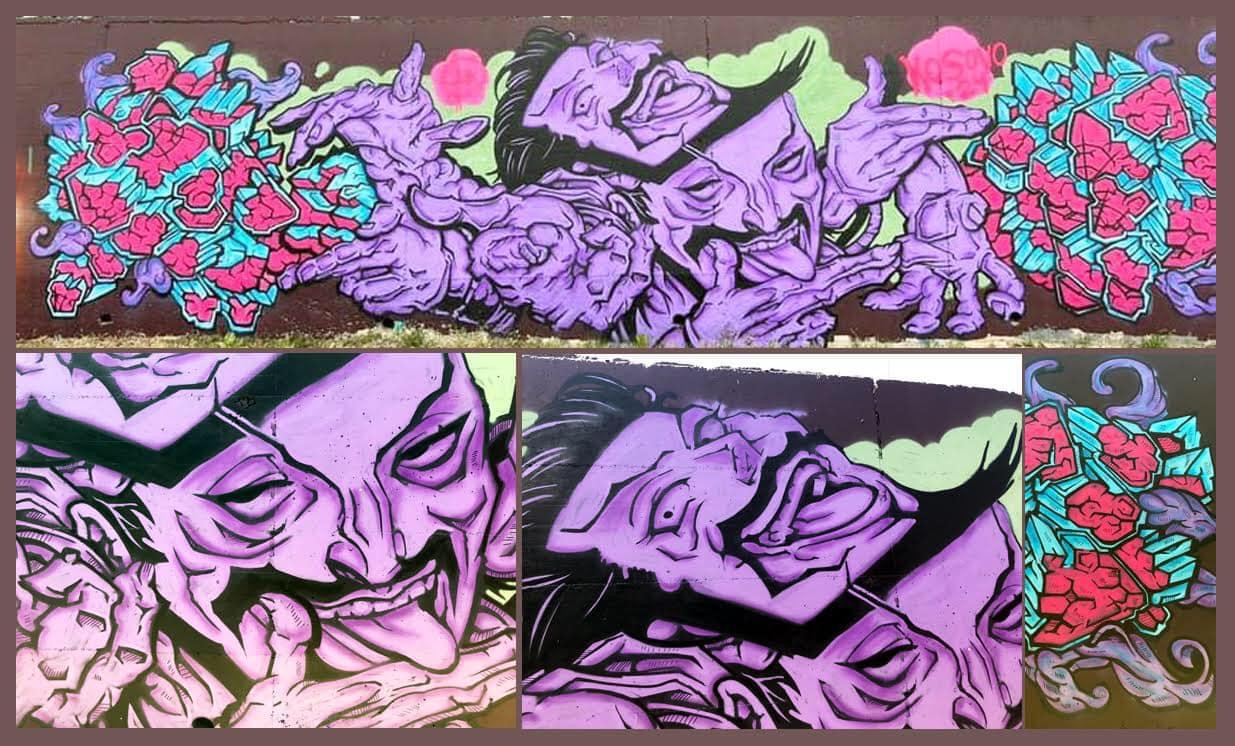 Colorful graffiti mural with faces, flowers, and abstract designs in purple, pink, blue, and green hues.