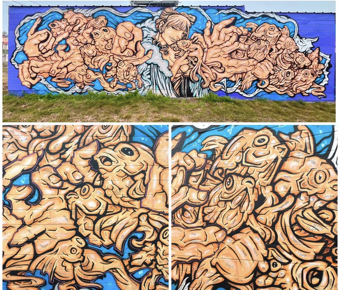 Mural with intricate, swirling patterns resembling faces and figures, in shades of beige, blue, and black, on a wall.