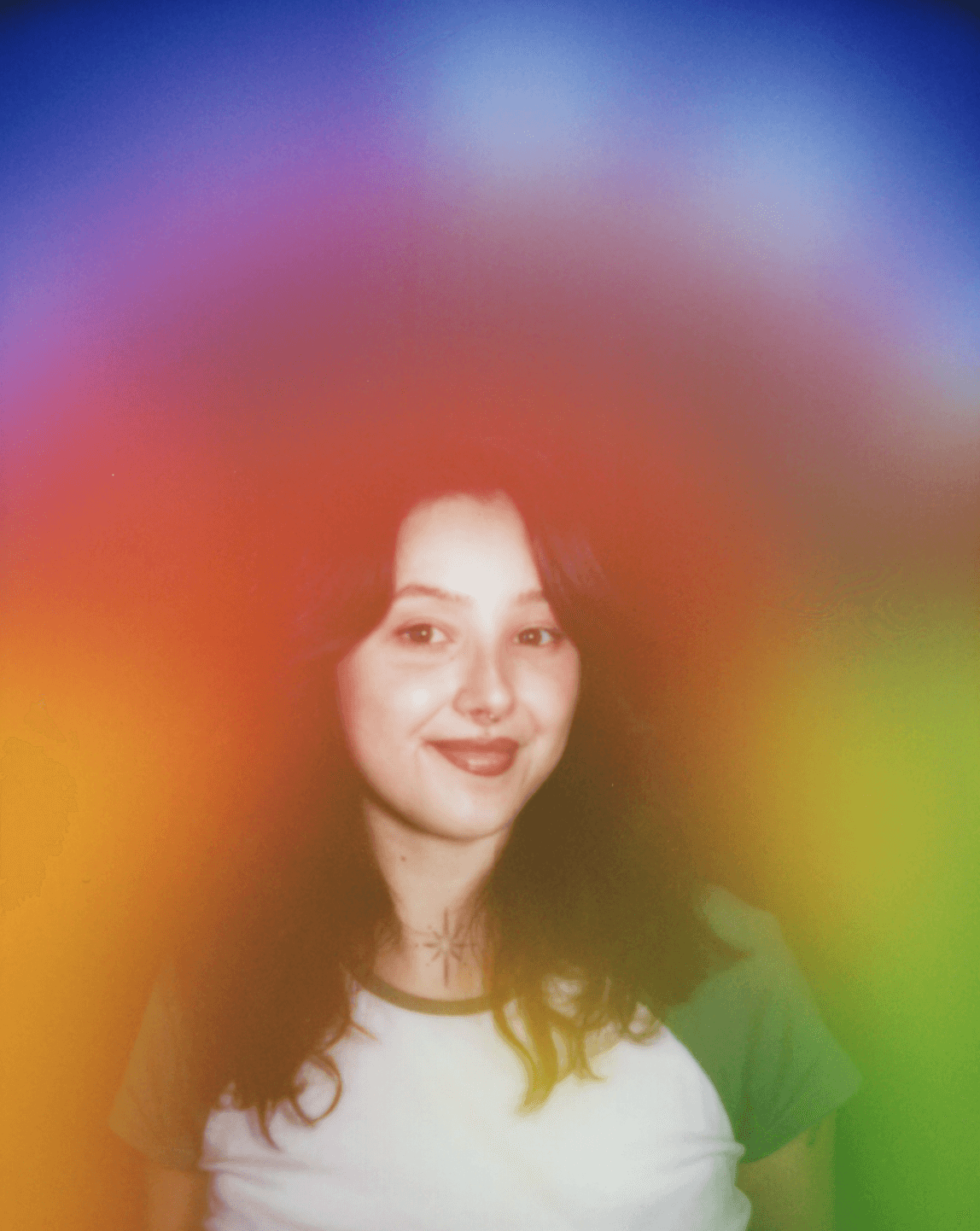 Young woman with long dark hair smiling, surrounded by colorful blurred lights.