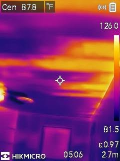 Thermal image showing warm and cool areas, with temperature scale on the right, and a crosshair in the center.