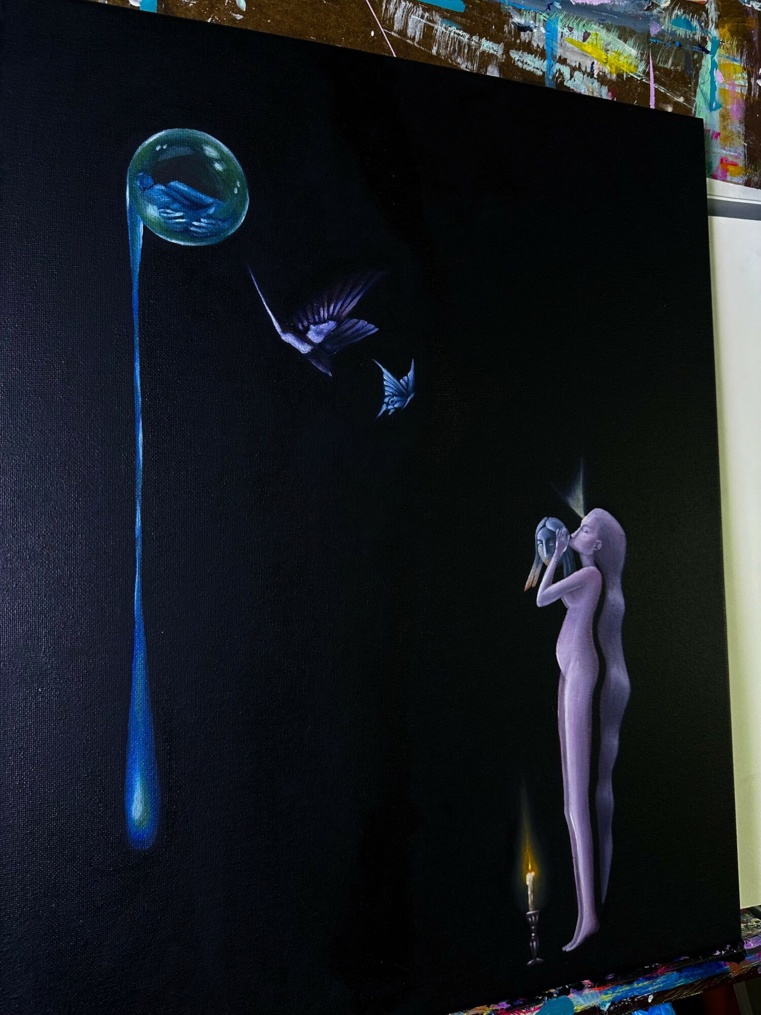 A nude woman stands with hands near her face, surrounded by dark background, with a glowing candle and floating objects.