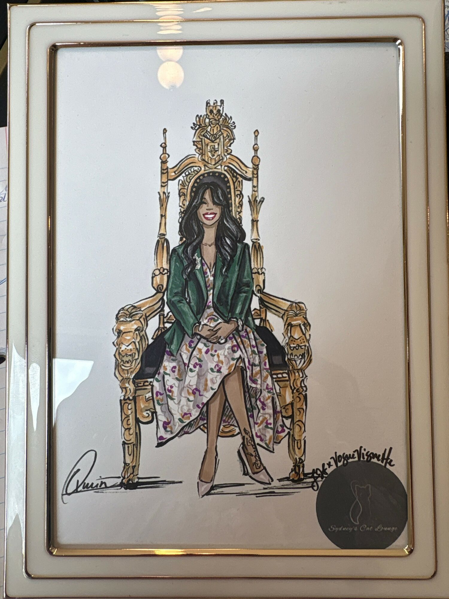 A woman sitting on an ornate golden throne with a high back and armrests, wearing a green jacket and floral dress.