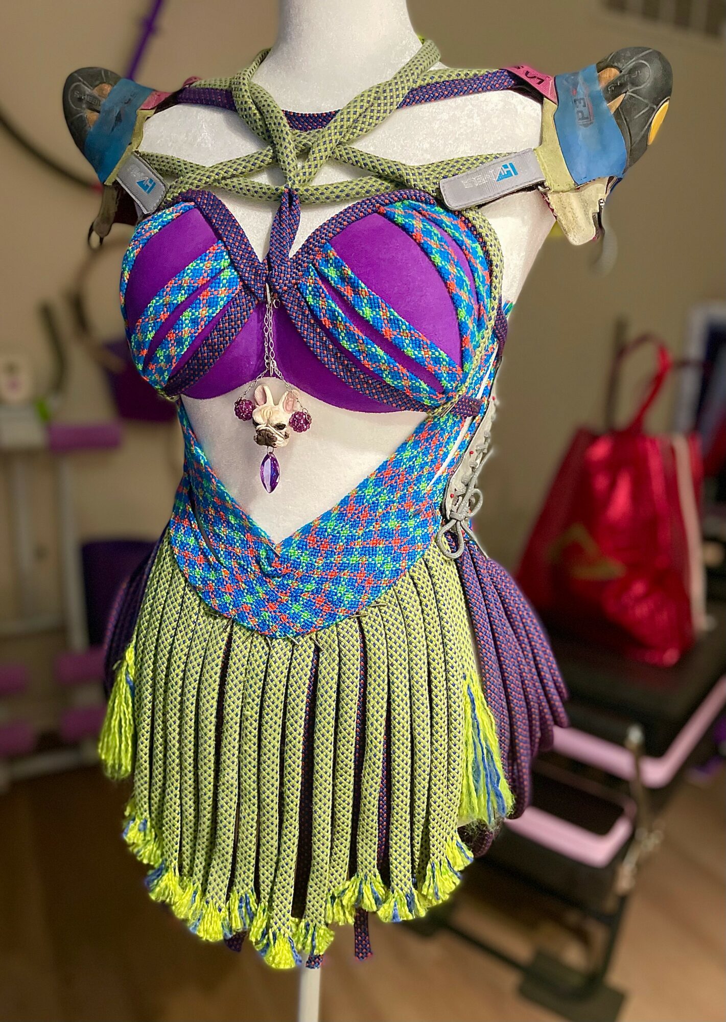 Colorful costume with a purple and blue top, green and purple skirt, and various accessories displayed on a mannequin.