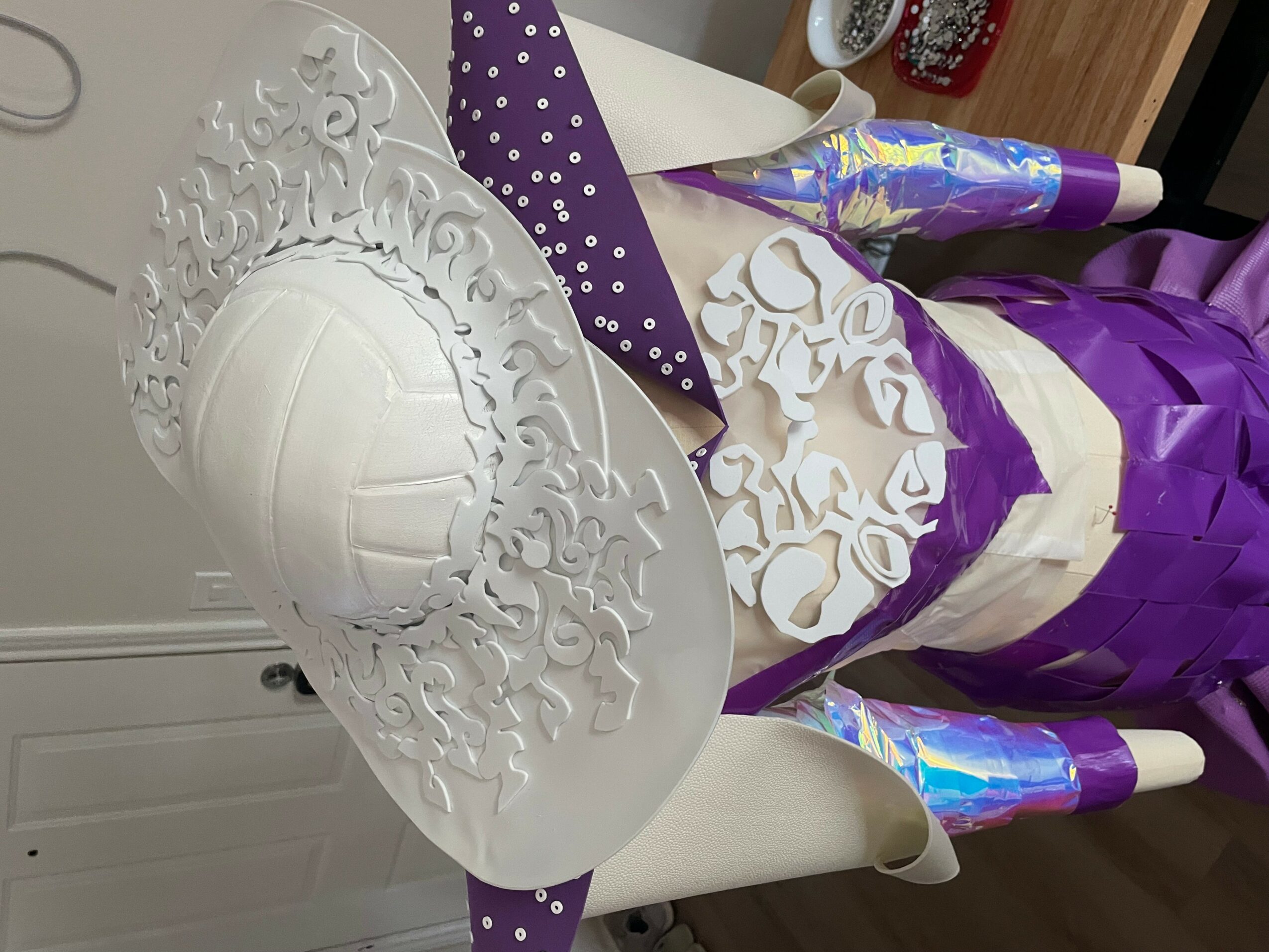 Decorated cake with white and purple icing, intricate white lace-like design, and candles on top.