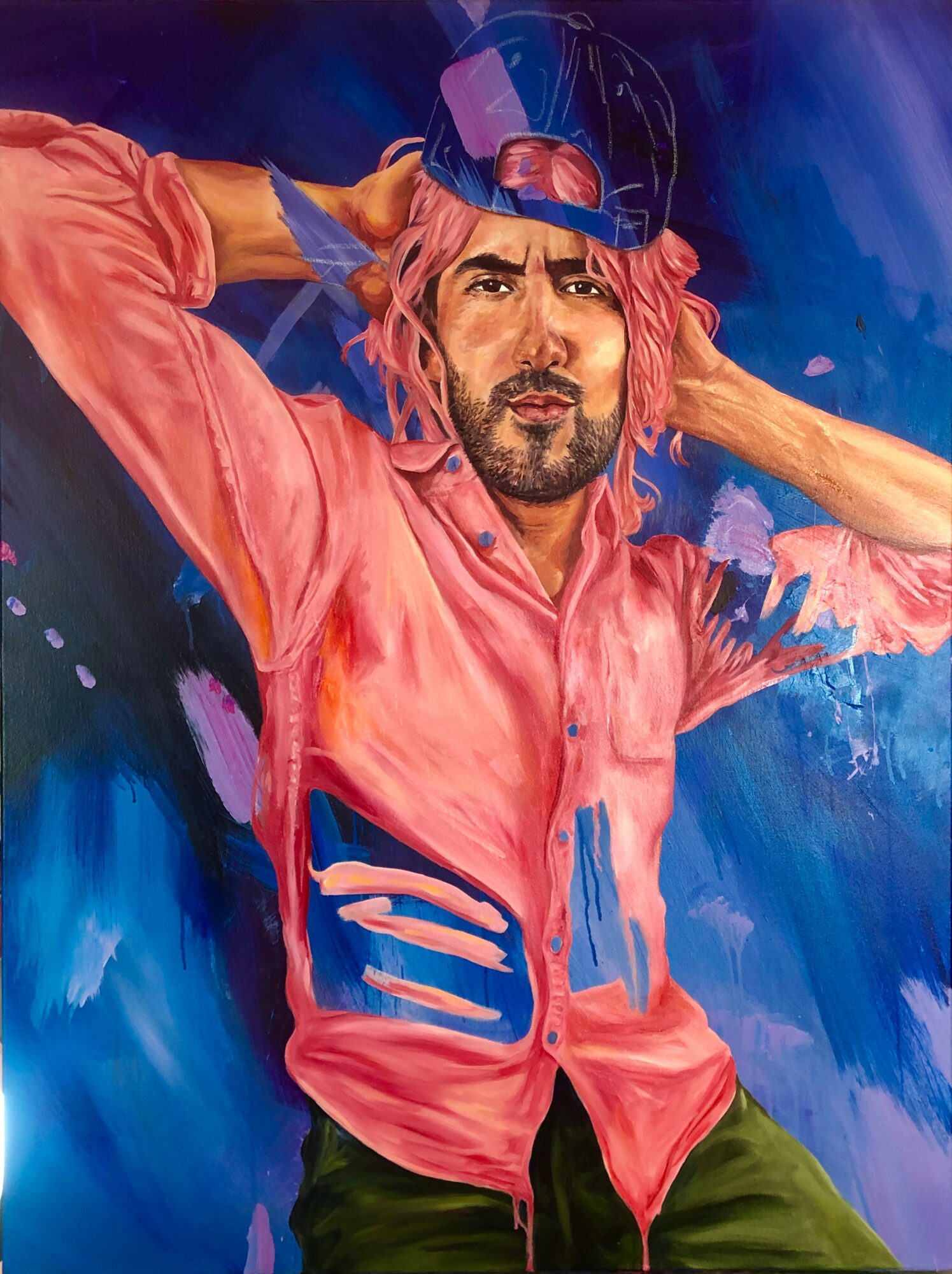 Portrait of a man with pink hair, wearing a pink shirt and a hat, against a blue background.