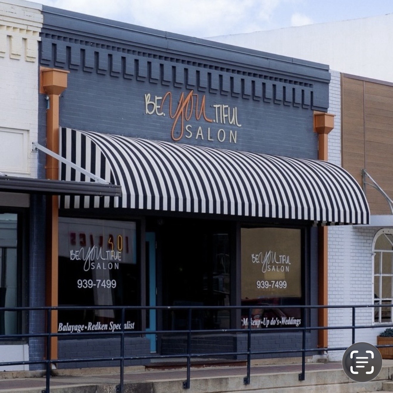 Salon storefront with striped awning, blue facade, and signage reading 'BEAUTIFUL SALON' with decorative elements.