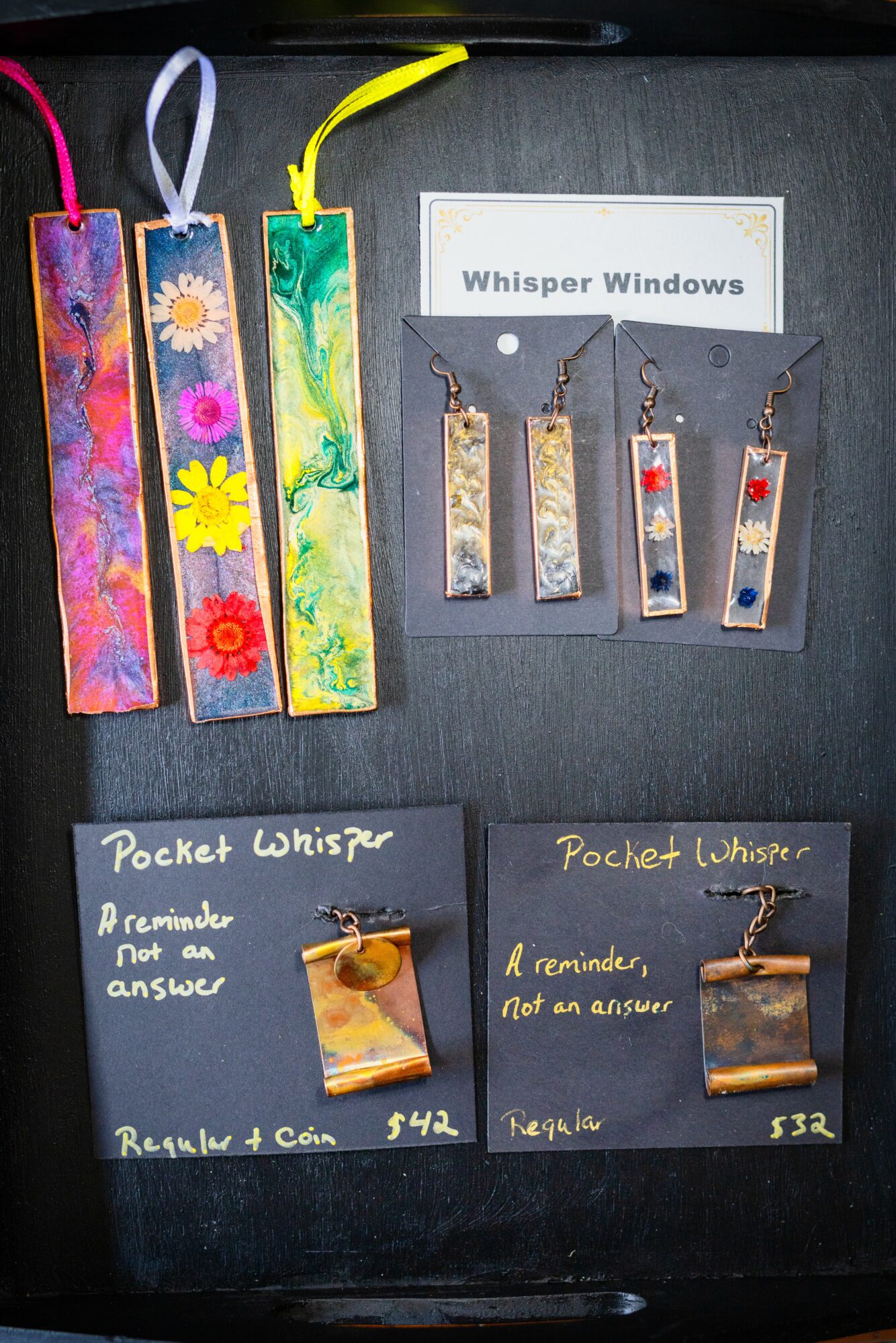 Four colorful rectangular objects with ribbons on top, a white card with