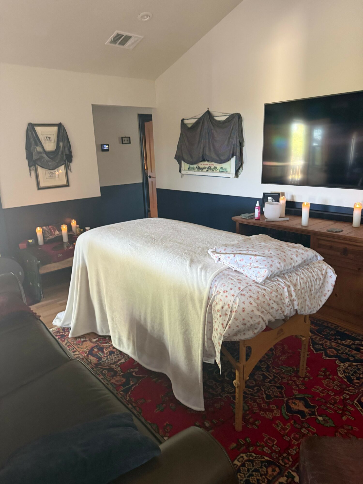 Bedroom with a bed, television, and a window with curtains, viewed from the side.