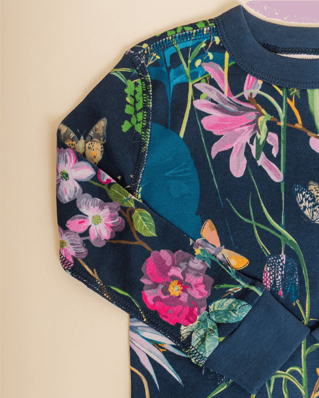Close-up of a colorful floral-patterned shirt with a navy background, showing the shoulder and sleeve area.