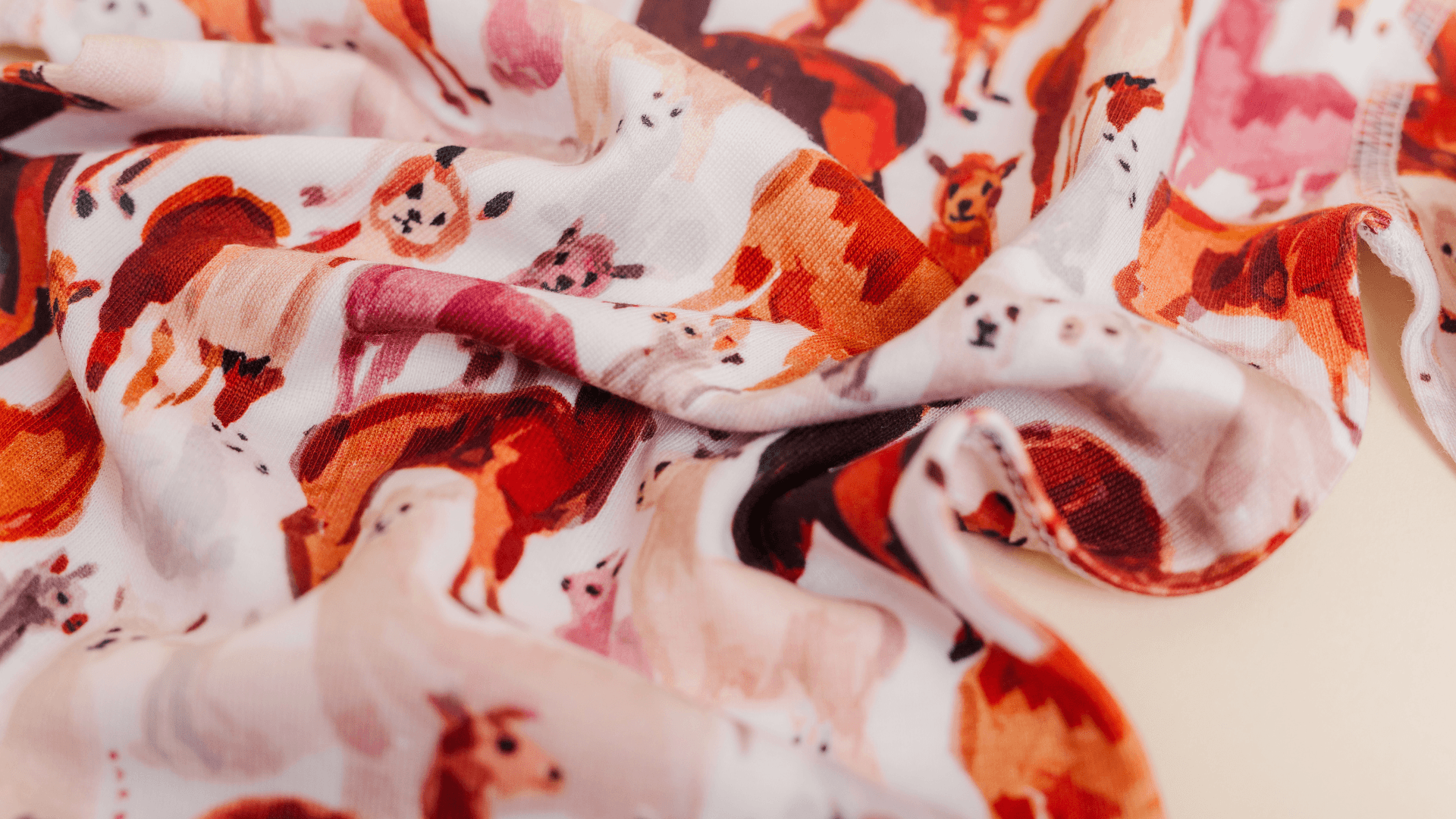 Fabric with colorful dog illustrations, crumpled and folded, on a white background.