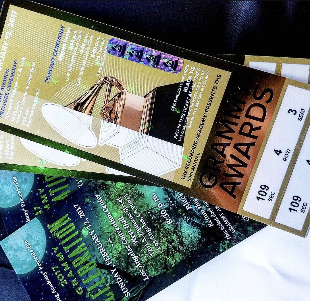 Two event tickets, one for the Grammy Awards, and a program or brochure with green and black design, partially visible.