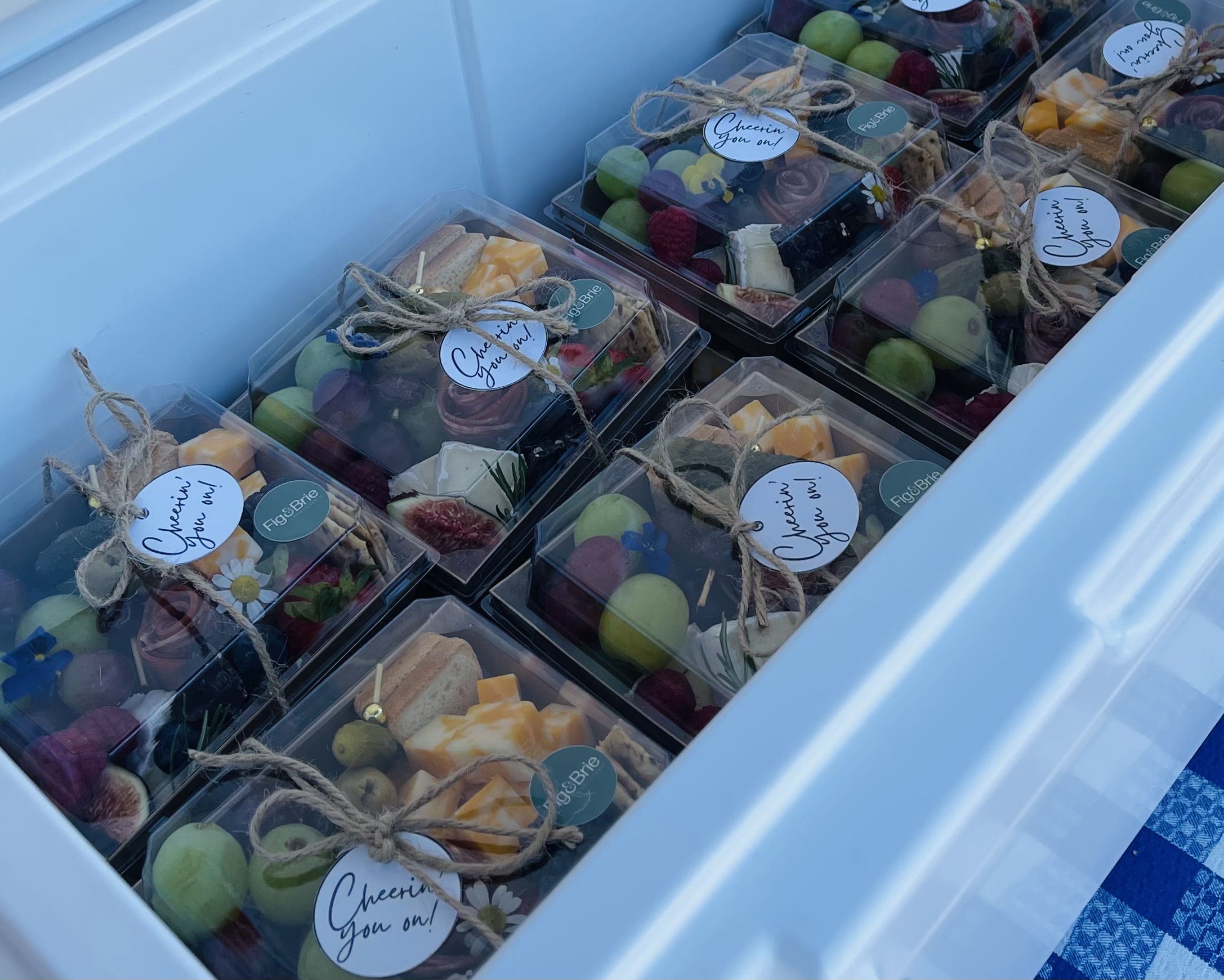 Boxes of assorted colorful candies and treats inside a cooler, each with a label and tied with string.