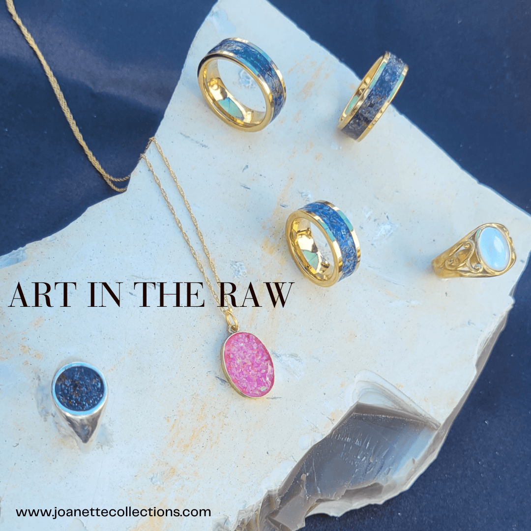 Jewelry including rings, a necklace with a pink pendant, and a ring with a large stone, displayed on a white surface.