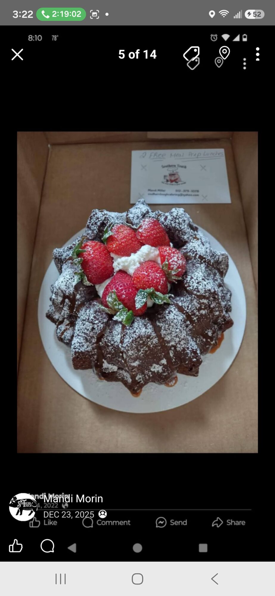 Plate of chocolate brownies topped with strawberries and powdered sugar, with a certificate in the background.