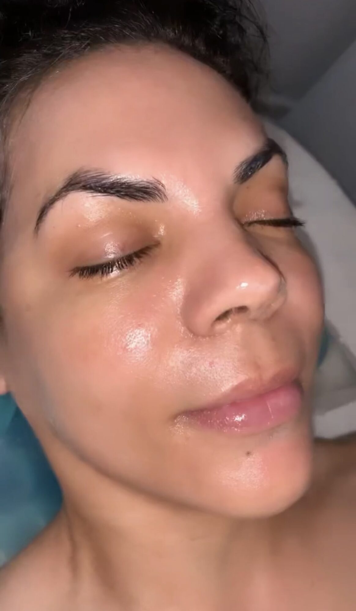 Close-up of a woman's face with closed eyes, smooth skin, and relaxed expression.