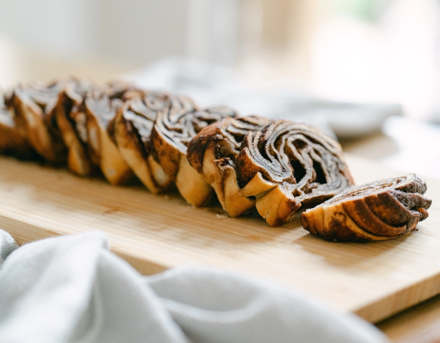 Chocolate and vanilla swirl cake slices on a wooden board with a blurred background.