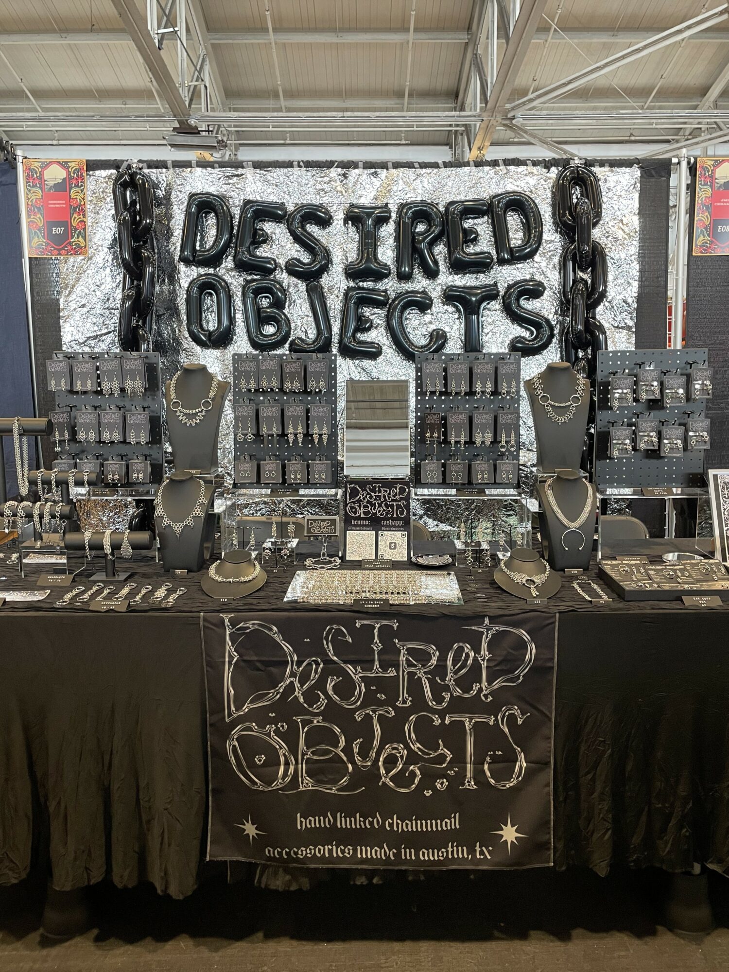 Display of jewelry and accessories with a sign reading 'DESTROYED OBJECTS' in water splash effect, and a blackboard with similar text.