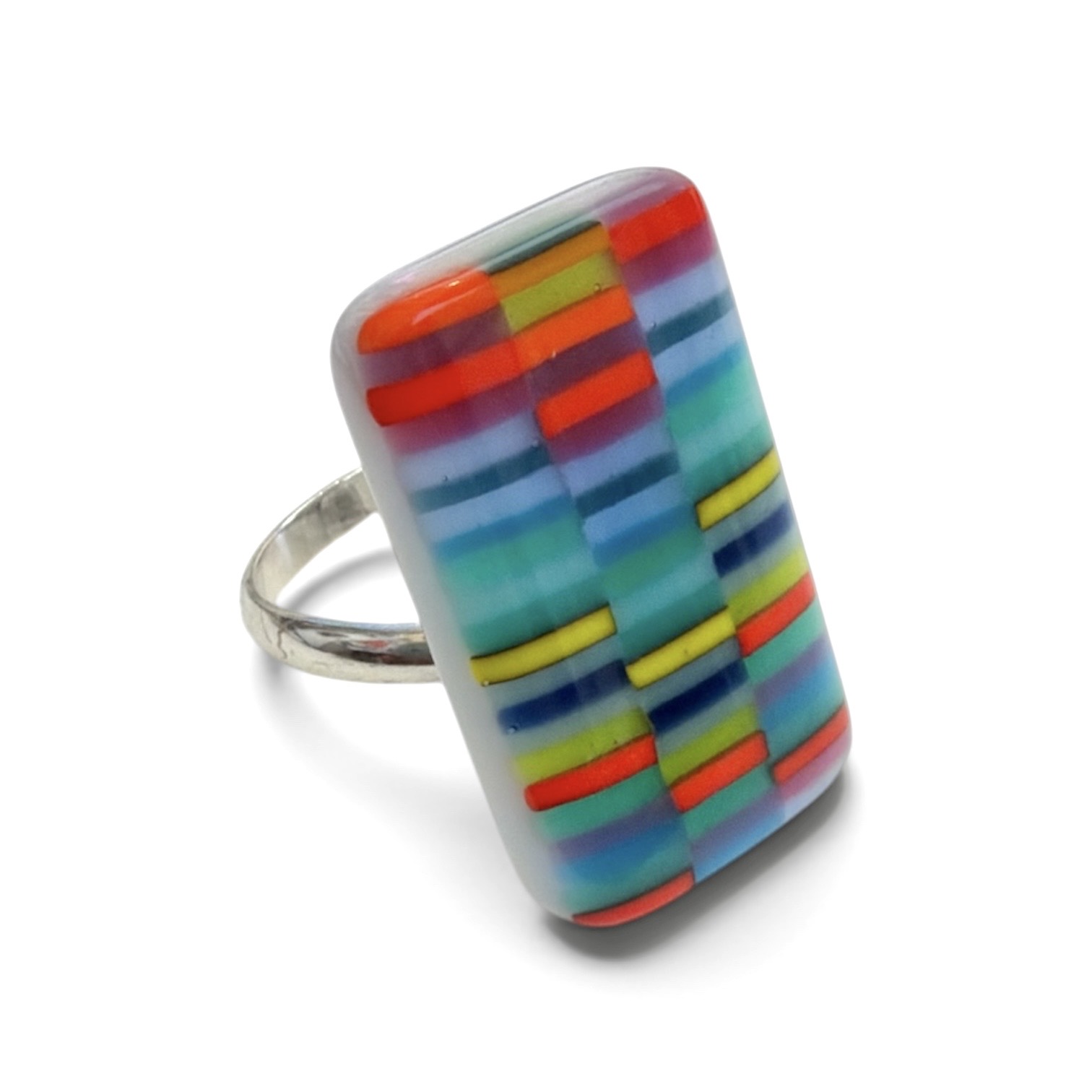 Ring with a rectangular, colorful, striped pattern on top, featuring red, blue, yellow, and green colors, on a white background.