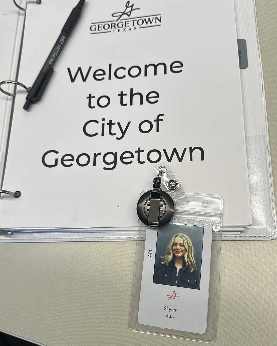 Welcome sign for Georgetown city with a name badge and pen on a white surface.