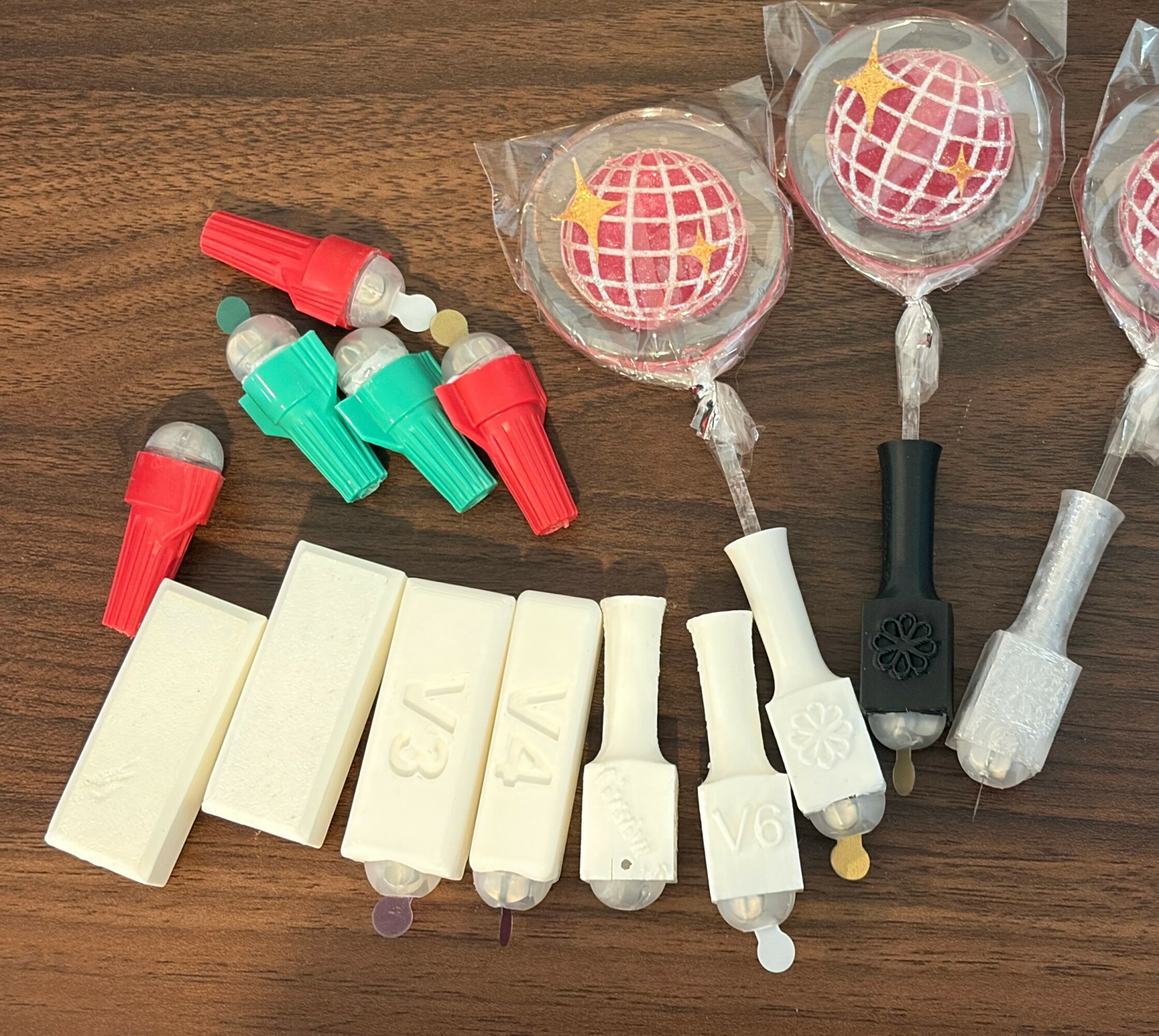 Various dental impression materials and tools on a wooden surface, including syringes, impression trays, and wrapped candies.