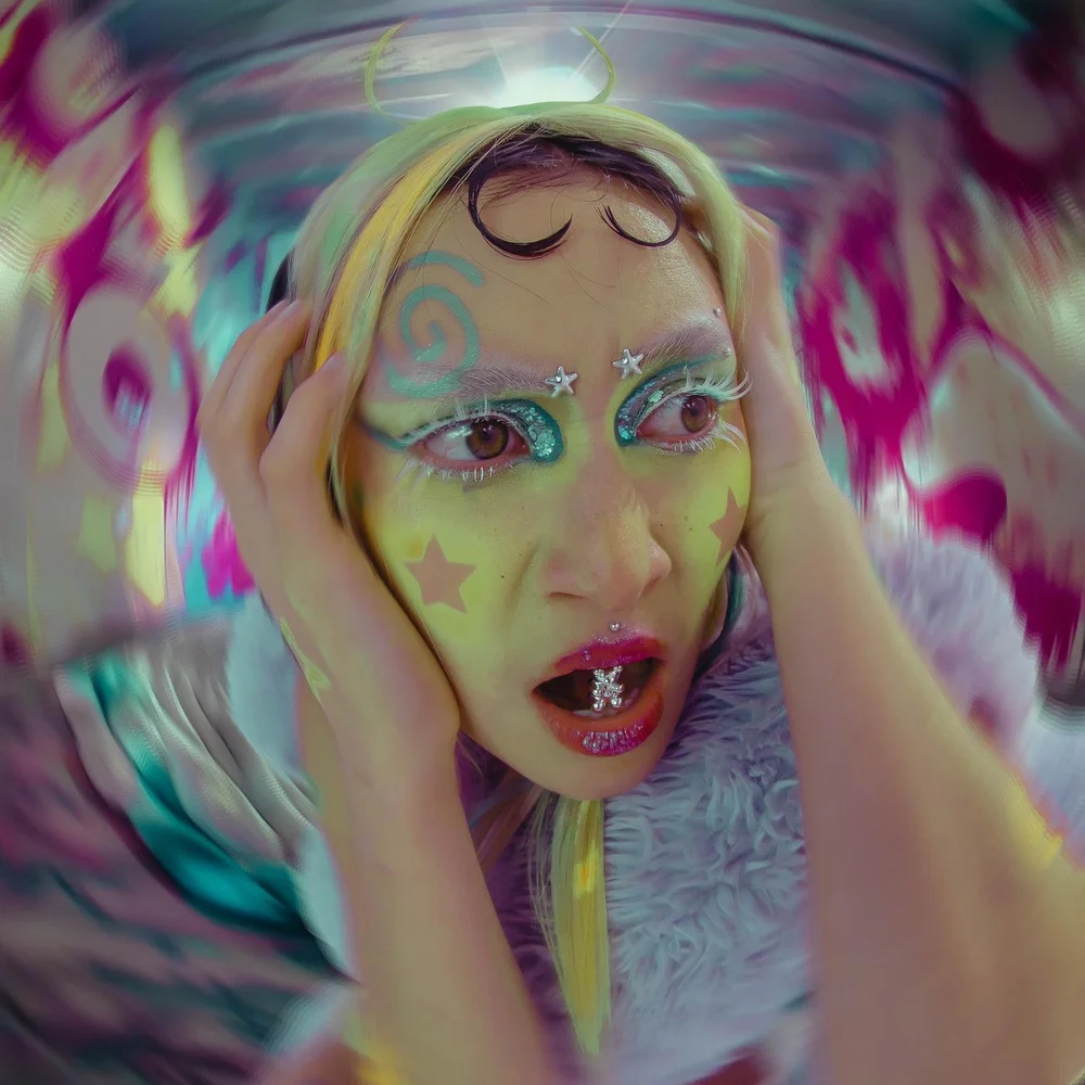 Person with colorful makeup and decorations, holding head, surrounded by vibrant, swirling background.