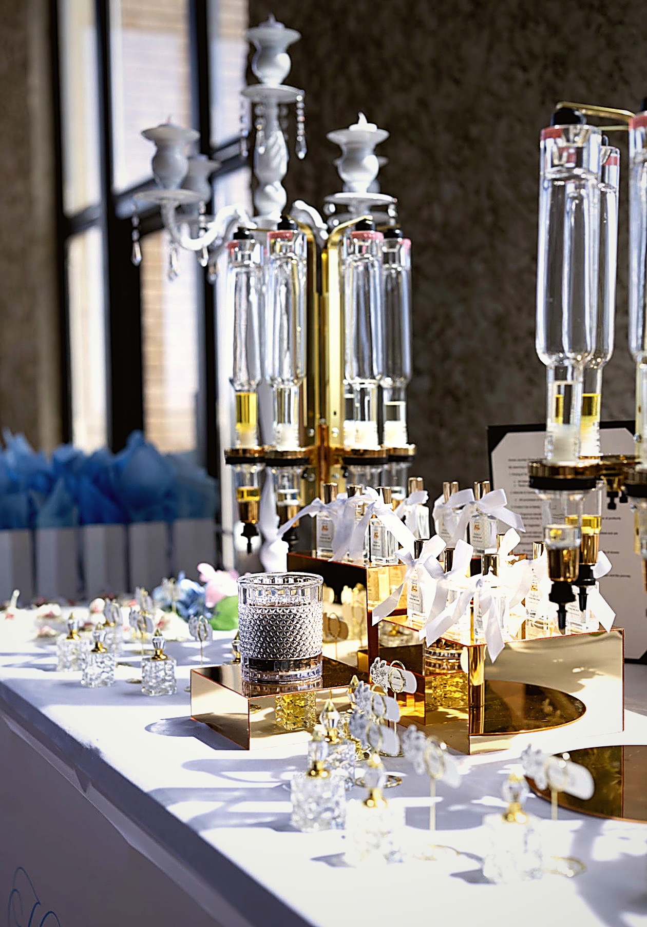 Elegant display of glass decanters and decorative items on a table with sunlight streaming in, creating reflections and shadows.