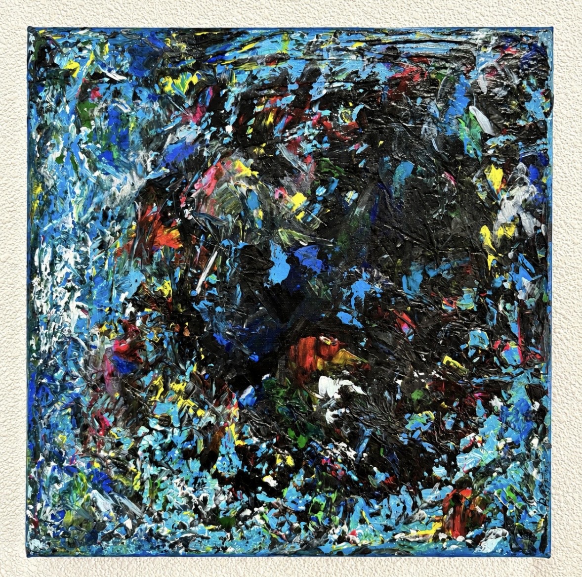 Abstract painting with vibrant blue, black, yellow, red, and white splashes and strokes, creating a dynamic composition.